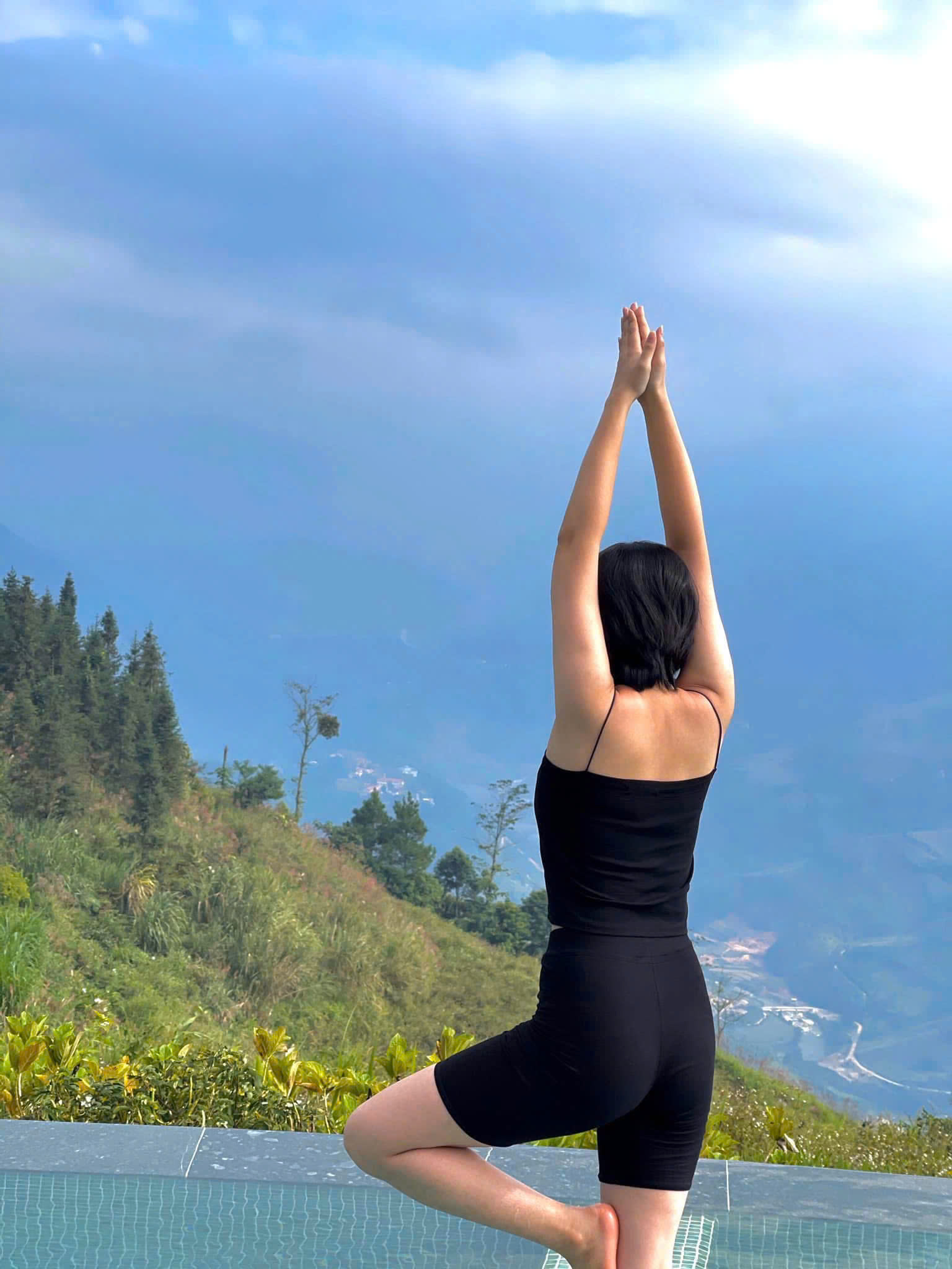 Tư thế yoga cái cây bên hồ bơi giữa núi